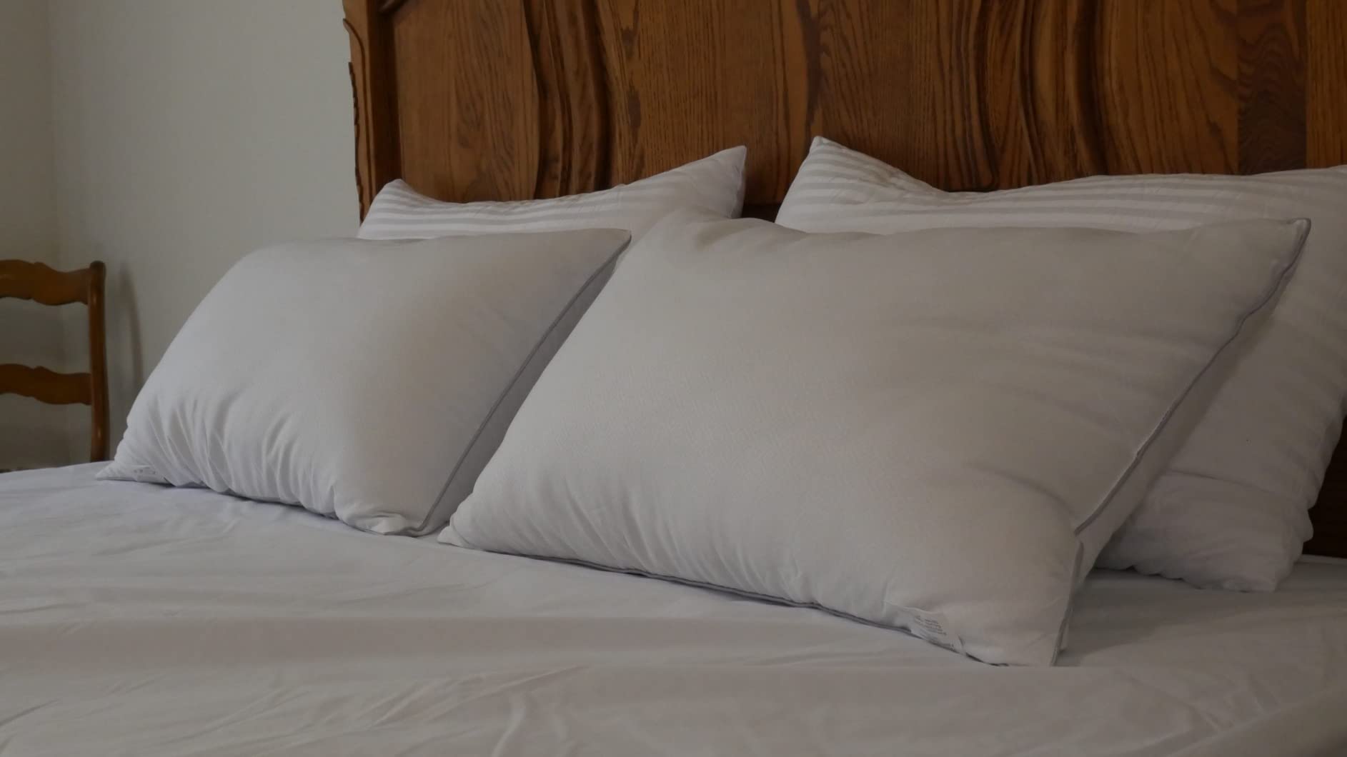 A comfortable bed with two Pozino two-pack cooling pillows and a wooden headboard, ideal for a relaxing bedroom setting.