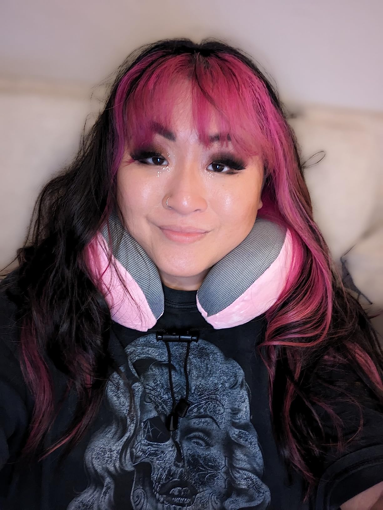 A woman with pink hair and a pink headband is seen using the GOTDYA Travel Pillow, showcasing its comfort and style.